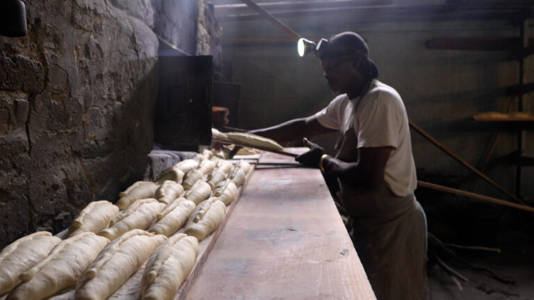 Baker working beside the brick oven at South Street Bakery in Antigua