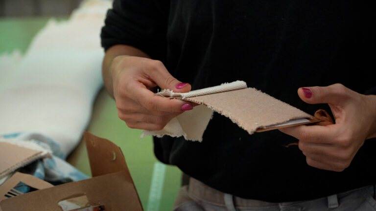 Hands showing swatches of naturally coloured cotton