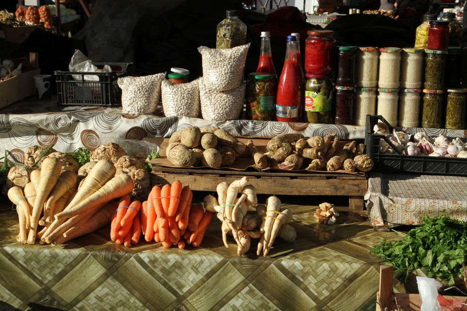 Fresh vegetables and jars of preserves at a farmers market